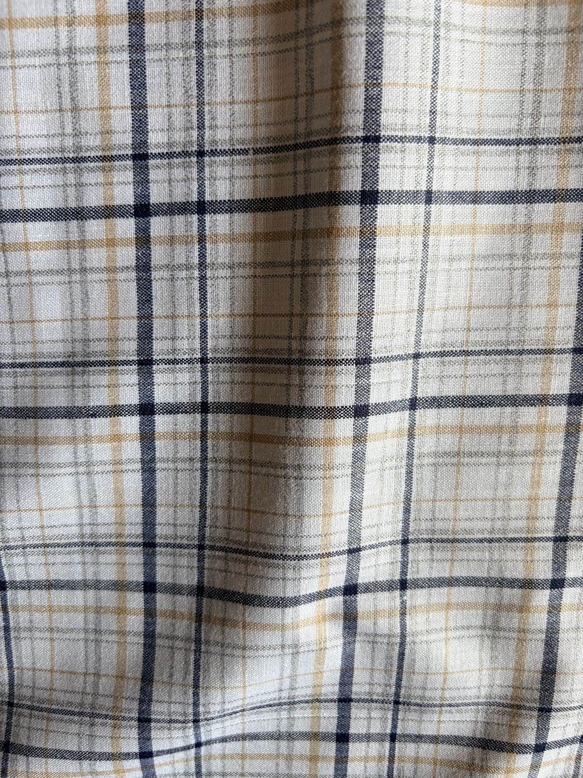 Deep Navy and warm mustard yellow lines set against a soft, neutral white base Shirting Fabric
