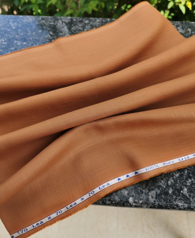 Brown fabric with a measuring tape on a marble surface