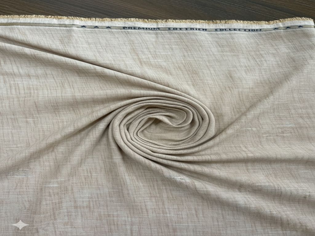 Rolled beige fabric with a subtle pattern on a wooden surface