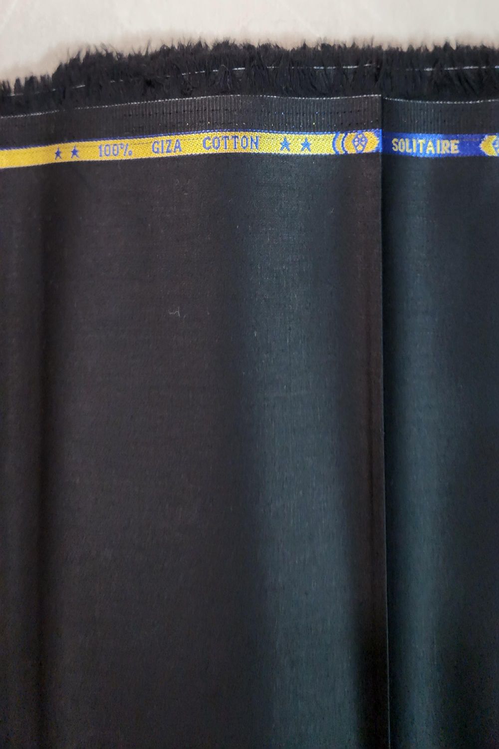 Dark fabric with a visible brand label on a plain background
